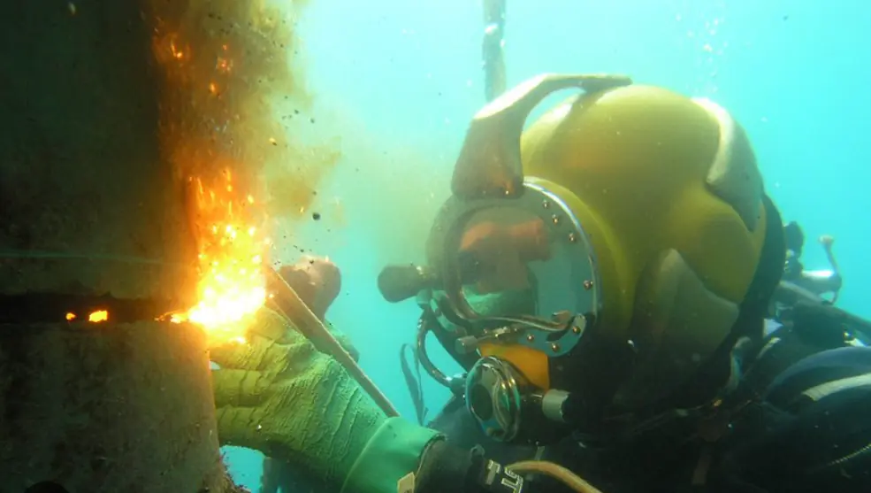 Buzo reparando pilote con soldadura